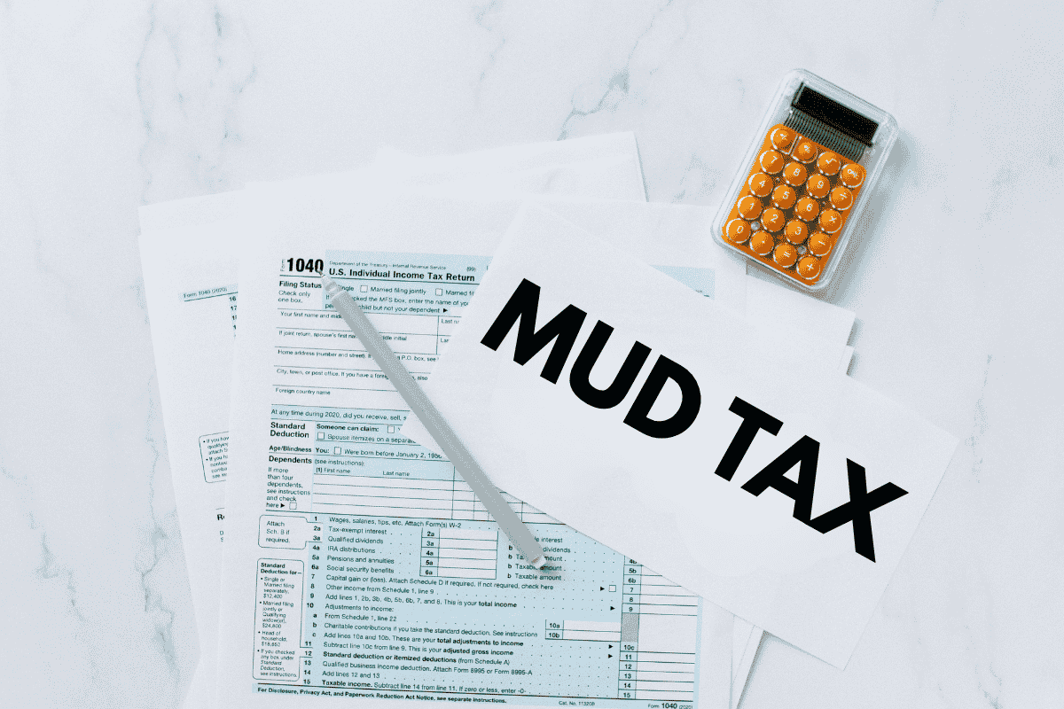 Tax forms for Texas homeowners, with a paper in front showing "Mud Tax" and a calculator above